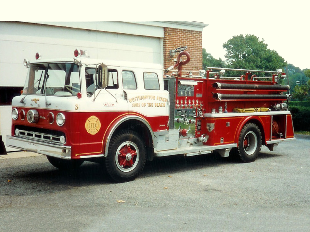 A vintage red and white fire truck is parked in front of a building. It has shiny equipment and hoses on its side, and the words "VENTNOR CITY BEACH" are visible on the door.