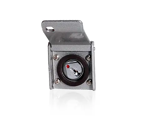 A small gray metal box with a hinged cover and a built-in round compass inside, showing directional markings and a red indicator.